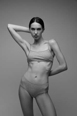 Portrait of beautiful young woman with perfect slim body posing in underwear. Black and white photography. Concept of natural beauty, body and skin care, sport, femininity, self-acceptance, adの写真素材