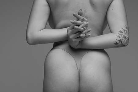 Cropped rear view image of female back and buttocks. Black and white photography. Medical care. Concept of beauty, body and skin care, health, plastic surgery, medicine, cosmetics, adの写真素材
