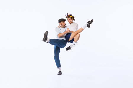 Portrait of couple, man and woman, dancing retro dance isolated over white studio background. Swing, boogie woogie. Concept of vintage fashion, hobby, activity, art, music, party, creativity and adの写真素材