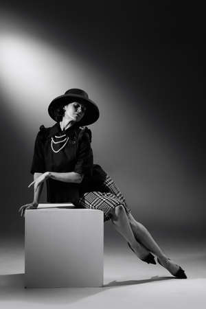 Portrait of beautiful woman in image of famous fashion designer posing in stylish classical outfit. Black and white photography. Grace and elegance. Monochrome effect. Fashion, style, history conceptの写真素材