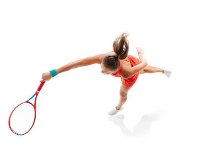 Top view portrait of woman, professional tennis player hitting ball with racket, training isolated over white background. Concept of sport, health, action, motion, hobby, lifestyle. Copy space for adの写真素材