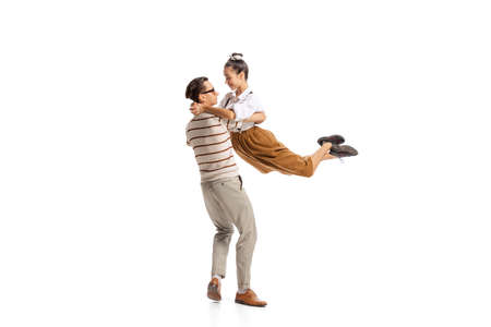 Portrait of stylish man and woman in retro outfit posing together isolated over white studio...