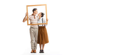 Portrait of man and woman posing together in a picture frame, kissing isolated over white background. Retro style.. Family look. Concept of fashion, relationship, creativity, business, expression, adの写真素材