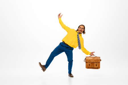 Portrait of stylish man, office worker in bright outfit posing with briefcase isolated over white studio background. Concept of human emotions, office, success, career, expression. Copy space for adの写真素材