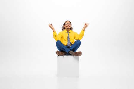 Portrait of calm man, office worker in official clothes sitting and meditating. Work break. Resting....