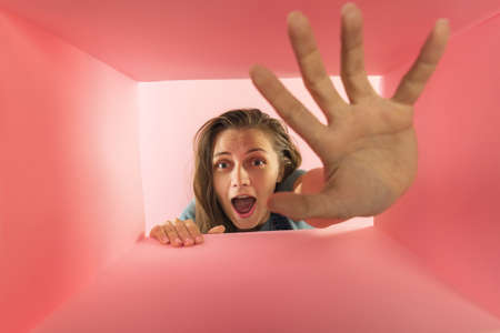 Happy and excited young woman looking inside carton box. Receiving long-awaited packages. Delivery service. Concept of gifts, shopping, emotions, facial expression. Unpacking box.の写真素材