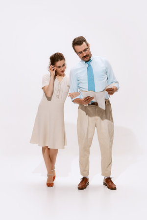 Portrait of couple, man and woman reading documents together isolated over white background. Concept of love, relationship, retro style, creativity, family. Copy space for adの写真素材