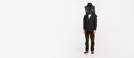 Portrait of stylish man in brown suit covering face with briefcase isolated over white studio background. Concept of retro fashion, style, vintage, character, creativity, youth culture, emotions, adの写真素材