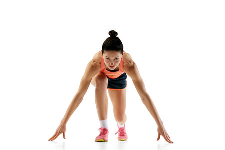 At start line. One sportive girl in sports uniform isolated over white background. Concept of sport,...