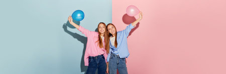 Carefree youth. Beautiful and happy teen girls, sisters or friends standing with balloons isolated...