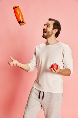Healthy lifestyle. Mature happy man with beard wearing home sportswear isolated over pink background. Concept of active lifestyle, positive emotions, sport, fitness, adの写真素材