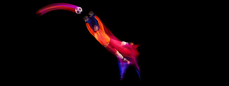 Sportive energetic man, soccer football goalkeeper in action, motion over dark background with mixed...