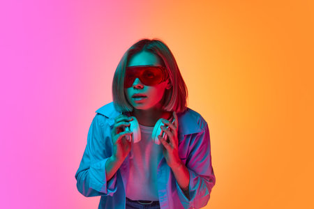 Curiosity and interest. Young emotional girl wearing fashionable eyewear posing over gradient...