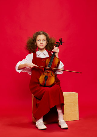 Portrait of little girl, talanted musician wearing huge mothers sundress playing violin, having fun isolated over magenta background. Pop art, education, music, classic art, new vision, fun conceptの写真素材