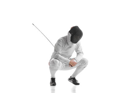 Sportive man, professional fencer in fencing costume and protective helmet mask has rest isolated on...