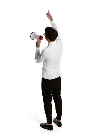 News, info, attention. Young man shouting at megaphone isolated over white background. Concept of business, office lifestyle, success, career, finance, ad. Studying and workingの写真素材