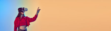 One teen girl wearing VR glasses over gradient blue-yellow background. Youth and virtual lifestyle of future. Concept of games, digitalization and technology. Banner with copys space for text, adの写真素材