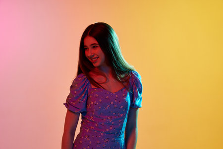 Smiling. Half-length portraits of happy girl with long hair wearing summer dress looking away over...