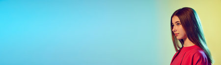 Confidence, calmness, dreaming. Charming girl looking away smiling over gradient blue-yellow background. Profile view. Concept of youth, education, fashion. Banner with copy space for text, adの写真素材