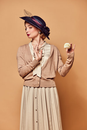 Rejection, dislike. One beautiful woman wearing retro style clothes holding cake with unpleasant...