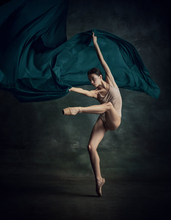 Solo performance. One emotional ballerina dancing with fabric on fingertips over dark green background. Aesthetic of ballet. The art, artist, movement, action and motion conceptの写真素材