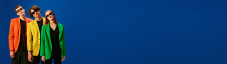 Banner of young team wearing stylish jackets and black sunglasses over blue background. Concept of fashion, models, styleの写真素材
