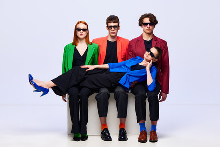 Team cohesion. Group of young people holding woman on knees symbolizing support over white background. Concept of work in team, models, business, online, teleworkingの写真素材