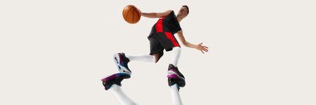 Banner with one basketball player training with ball over white background. Bottom view. Concept of...