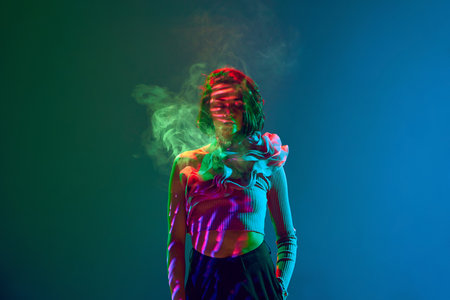 Portrait of stunning girl woman standing with closed eyes surrounded by smoke over neon blue and green gradient background. Concept of beauty, emotions, digital art, fashion, cyberpunk, futurismの写真素材