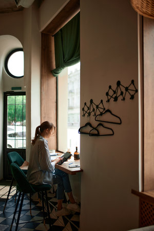 Portrait with business woman working on tablet sitting at cafe and managing her business remotely. Concept of freelance, online work, business people, remote job, career growth, ad conceptの写真素材