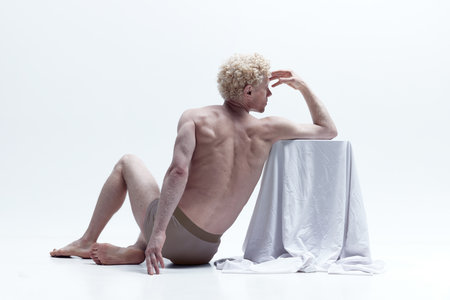 Antique sculpture. Muscular man posing in statue pose shirtless isolated over white studio background. Back view. Male body aesthetics, natural beauty, mens beauty, inspiration, art conceptの写真素材