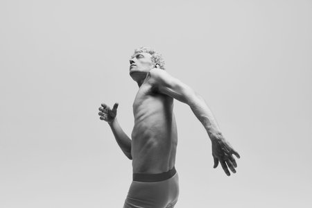 Portrait with man wearing underwear posing shirtless like antique sculpture, statue isolated over white studio background. Monochrome. Concept of male body aesthetics, mens beauty, art, adの写真素材