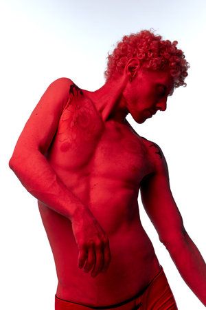 Handsome shirtless man, model in red colour filter posing isolated over white color background. Model posing like antique sculpture. Male body aesthetics, mens beauty, inspiration, art conceptの写真素材
