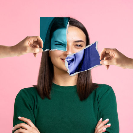 Human hands holding photo face parts with angry and happy expressions. Beautiful young woman and her...