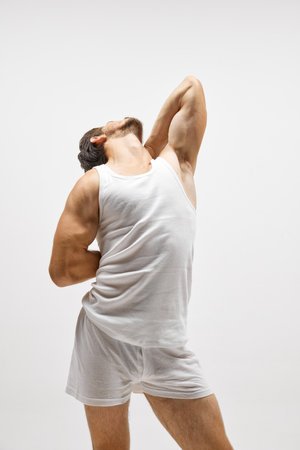 Portrait of handsome young dark-haired man posing isolated over studio background. Male natural beauty. Concept of mens health, posing, beauty, body and skin care. Fashionable lookの写真素材