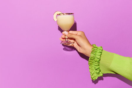 Horizontal photoshoot of female hand holding glass of pina colada on light pink background. Concept of design, party, relax, pop art. Copy space for adの写真素材