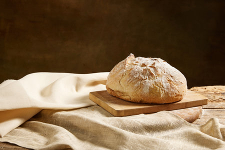 Composition with view from above of whole grain bread on rustic wooden board with tomatoes. Concept...