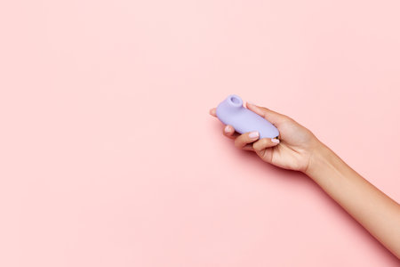 Womans health. Female hand with vibrator, medical massager over pastel pink background. Image for sex shop. Concept of healthy lifestyle , medicine. Copyspace for ad, textの写真素材