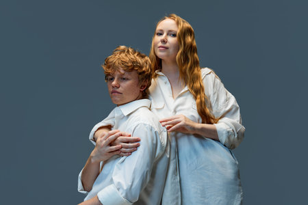 Young beautiful couple hugging in white t-shirts. Red hair woman in hug handsome redhead man against grey studio background. Concept of natural beauty, love, frienship, relationships, fashion. Ad.の写真素材
