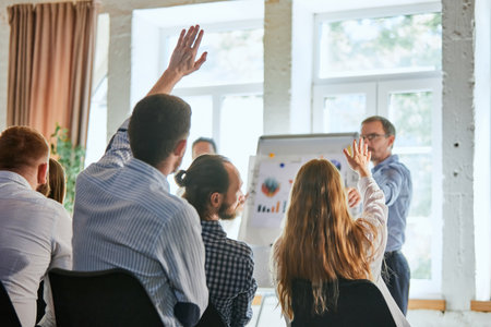 Business man raising hand during seminar. Hand up in conference asking to answer question in...