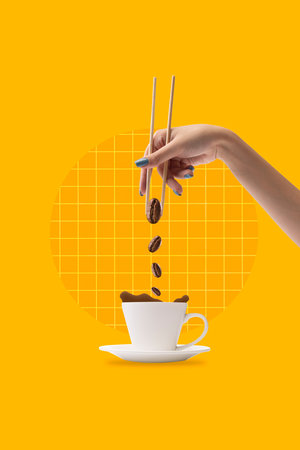 Creative design with female hand holding coffee beans with chopsticks and putting it into coffee cup on yellow background. Concept of drink, taste, art, colorful design. Poster. Copy space for ad.の写真素材