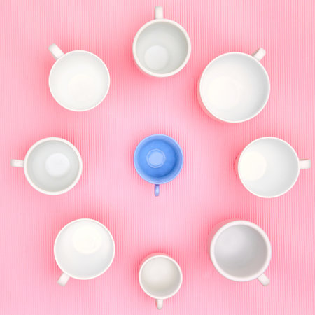 Top view photo of plenty variety of clean white elegant porcelain coffee or tea cups und one blue plastic cup. Concept of food, holiday, table setting, retro, vintage, etiquette, ethics, decorumの写真素材
