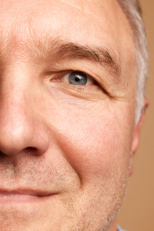 Close-up cropped photo of middle aged, 45s man isolated beige studio background. Concept of natural beauty, skincare, health care, facial expression, anti-aging and spa treatment.の写真素材