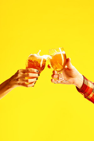 Couple toasts with glasses of cold beer. Male and female hands holding lager light and dark beer mugs and clinking with splash. Concept of alcohol, Oktoberfest, celebration, party, fans, friends. Adの写真素材