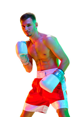 Muscular build man. Boxer, fighter exercising before fight against white background in mixed neon filter, light. Concept of sport, action, motion, healthy lifestyle. Copy space for ad.の写真素材