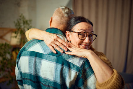 Elderly love. Old couple relax at home in happy retirement. Senior woman, wife hug her man, husband while dancing in living room at home. Concept of love, retirement life, pensioners, cozy, holidays.の写真素材