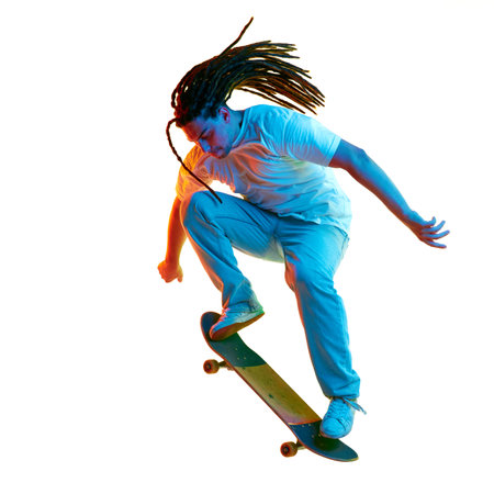 Full-length portrait of man dressed modern stylishly outfit skateboarding in neon light, filter isolated white background. Concept of youth culture, active lifestyle, style and fashion, creativity.の写真素材