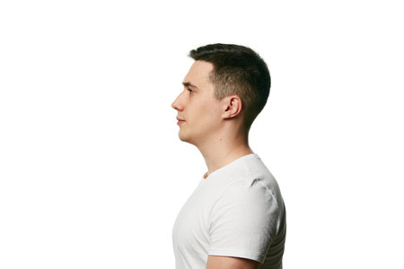 Side view portrait of man of attractive appearance, well-groomed looking at camera against white background. Concept of beauty treatment and hygiene, body care, anti-aging procedures. Copy space. Adの写真素材