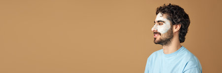 Banner. Calm brunette, bearded man with dermatology facial care mask against beige studio background with negative space for text. Concept of beauty routine, cosmetic self care products, treatment.の写真素材