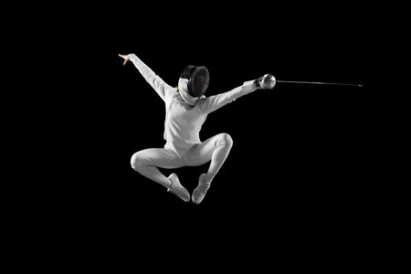 Dynamic mid-air snapshot of swift motion of female fencers blade, dynamic lines and angles of her body during fight against black studio background. Concept of professional sport, championship. Adの写真素材